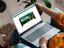 Eine Frau mit Laptop auf den Beinen. 